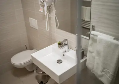 a bathroom with a white sink and a toilet at Princ Apartment in Niš