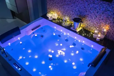 a jacuzzi tub in a bathroom with lights at Princ Apartment in Niš