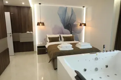 a bathroom with a bed and a bath tub at Princ Apartment in Niš