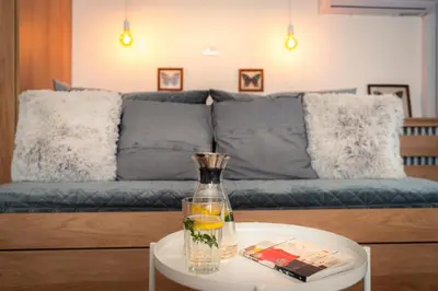 a vase on a table in front of a couch at Kuća Jankovića in Vrnjačka Banja