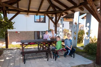 a group of people sitting at a picnic table at Kuća Jankovića in Vrnjačka Banja