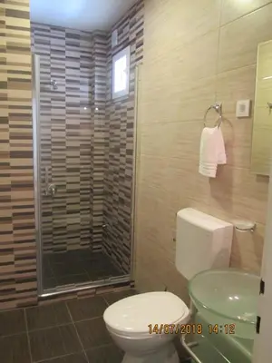 a bathroom with a toilet and a glass shower at Kuća Popović Apartments in Niš