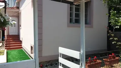a house with a green lawn in front of it at Kuća Popović Apartments in Niš