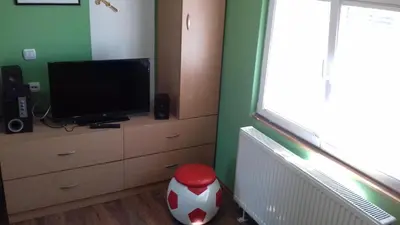 a living room with a tv and a dresser with a televisionicter at Sweet dreams in Zaječar