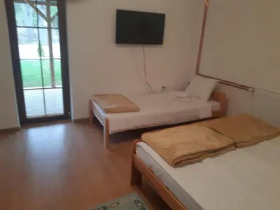 a room with two beds and a flat screen tv at Apartmani Gmitrovic in Rtanj