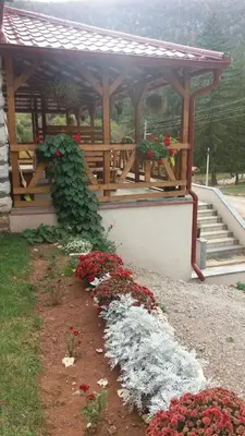 a pavilion with a bunch of red and white flowers at Apartmani Gmitrovic in Rtanj