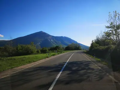 an empty road with a mountain in the background at Apartmani Gmitrovic in Rtanj