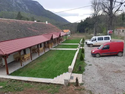 a red van parked in a parking lot next to a building at Apartmani Gmitrovic in Rtanj
