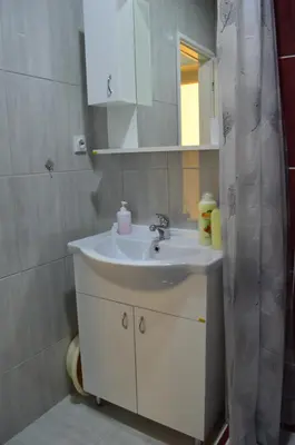 a bathroom with a sink and a shower curtain at Apartman Linera in Soko Banja