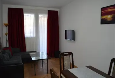 a living room with a couch and a glass table at Apartman Linera in Soko Banja