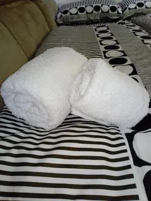 a white stuffed animal laying on a bed at Apartman ZVEZDA in Jagodina