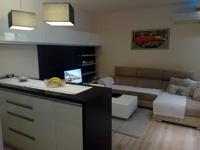 a kitchen and living room with a couch and a table at Apartman ZVEZDA in Jagodina