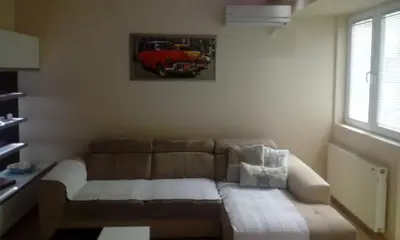 a living room with a couch and a picture of a car at Apartman ZVEZDA in Jagodina