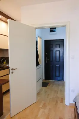 a door leading into a kitchen with a blue door at DM apartment in Niš
