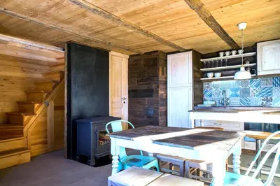 a kitchen with a table and a stove at Kostovac Boutique Homes - House 1 in Kopaonik