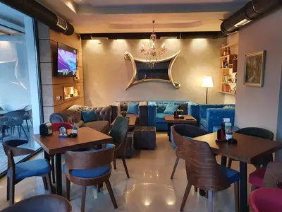 a restaurant with tables and chairs and a couch at Family Apartments in Zaječar
