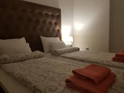 two beds in a hotel room with towels on them at Family Apartments in Zaječar