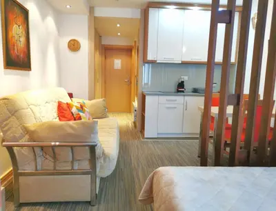 a living room with a couch and a kitchen at Premia Apartments Konaci in Kopaonik