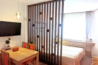 a room with a table and a bed and a table and a television at Premia Apartments Konaci in Kopaonik