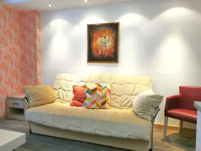 a living room with a white couch with colorful pillows at Premia Apartments Konaci in Kopaonik
