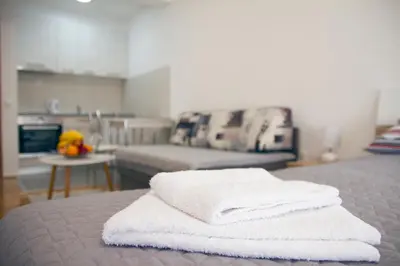 two white towels stacked on a bed in a room at Tea Studio Apartments in Niš