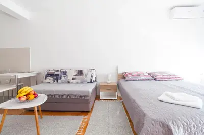 a bedroom with two beds and a table with fruit on it at Tea Studio Apartments in Niš