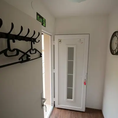 a room with a door and a clock on the wall at Apartments & Dream Rooms in Niš
