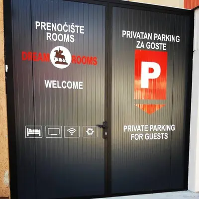 a black garage door with signs on it at Apartments & Dream Rooms in Niš