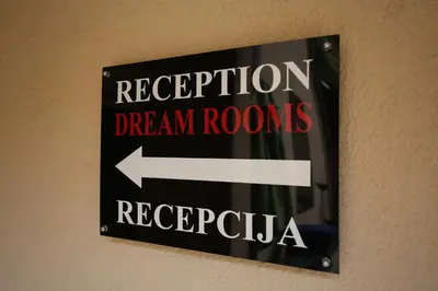 a sign on a wall that readsrificationdream rooms andragota at Apartments & Dream Rooms in Niš