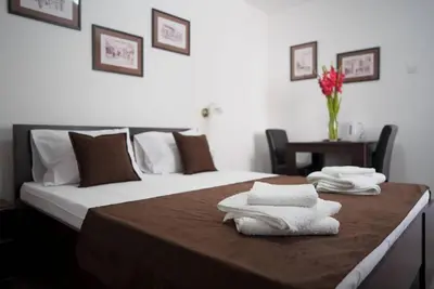 a hotel room with two beds with towels on a table at Apartments & Dream Rooms in Niš