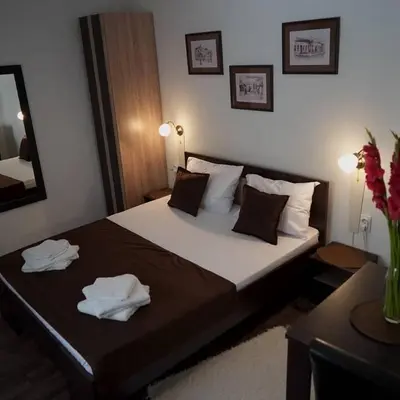 a bedroom with a large bed with towels on it at Apartments & Dream Rooms in Niš