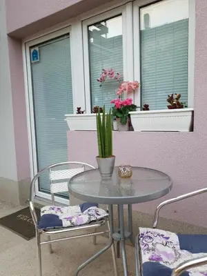 a table and chairs on a patio with windows at Vila Stefanovic in Soko Banja