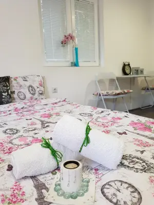 a bed with two towels and a candle on it at Vila Stefanovic in Soko Banja