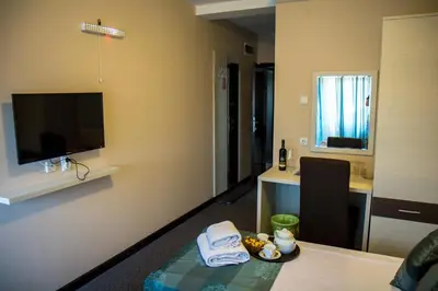a room with a table and a television on a wall at Hotel Danica in Vrnjačka Banja