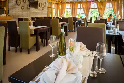 a dining room with tables and chairs with wine glasses at Hotel Danica in Vrnjačka Banja