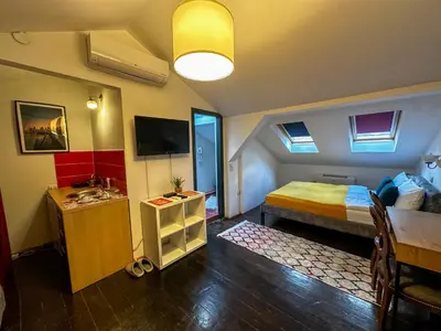 a room with a bed and a table and a television at THE ONLY ONE Accommodation in Niš
