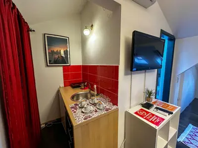 a bathroom with a sink and a tv on the wall at THE ONLY ONE Accommodation in Niš