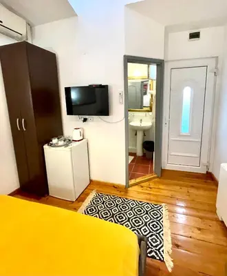 a bedroom with a bed and a television and a mirror at THE ONLY ONE Accommodation in Niš