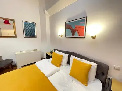 a living room with a white couch with yellow pillows at THE ONLY ONE Accommodation in Niš