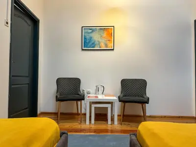 a room with two beds and a table with two chairs at THE ONLY ONE Accommodation in Niš