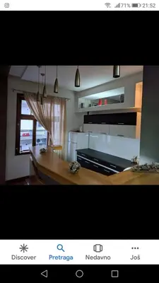 a picture of a kitchen with a dining table at Apartmani DiO in Niš