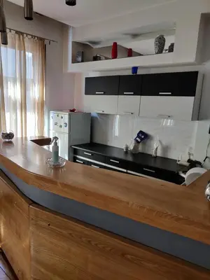 a kitchen with a wooden counter top in a room at Apartmani DiO in Niš