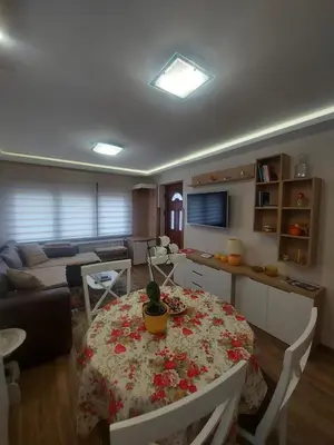 a living room with a table and a couch at Apartmani Nik Lux in Vrnjačka Banja