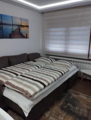 a large bed in a room with a window at Apartmani Nik Lux in Vrnjačka Banja
