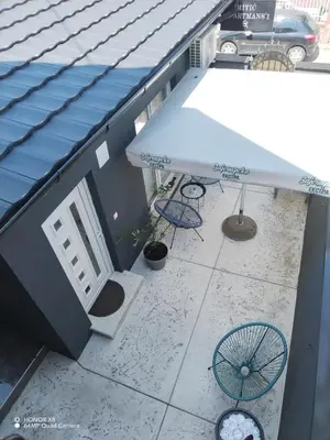 an overhead view of a patio with an umbrella and chairs at Mitić Apartmani 1 in Niš