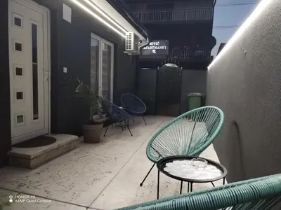 a patio with a chair and a table on a balcony at Mitić Apartmani 1 in Niš