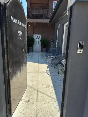 an entrance to a building with two chairs and a table at Mitić Apartmani 1 in Niš