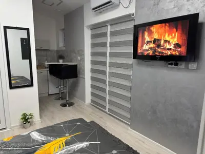 a living room with a tv hanging on a wall at Mitić Apartmani 1 in Niš
