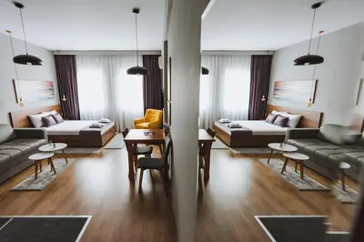 a living room with couches and tables and chairs at Central Plaza Apartments in Niš