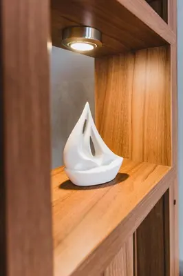 a white object sitting on top of a wooden shelf at Central Plaza Apartments in Niš